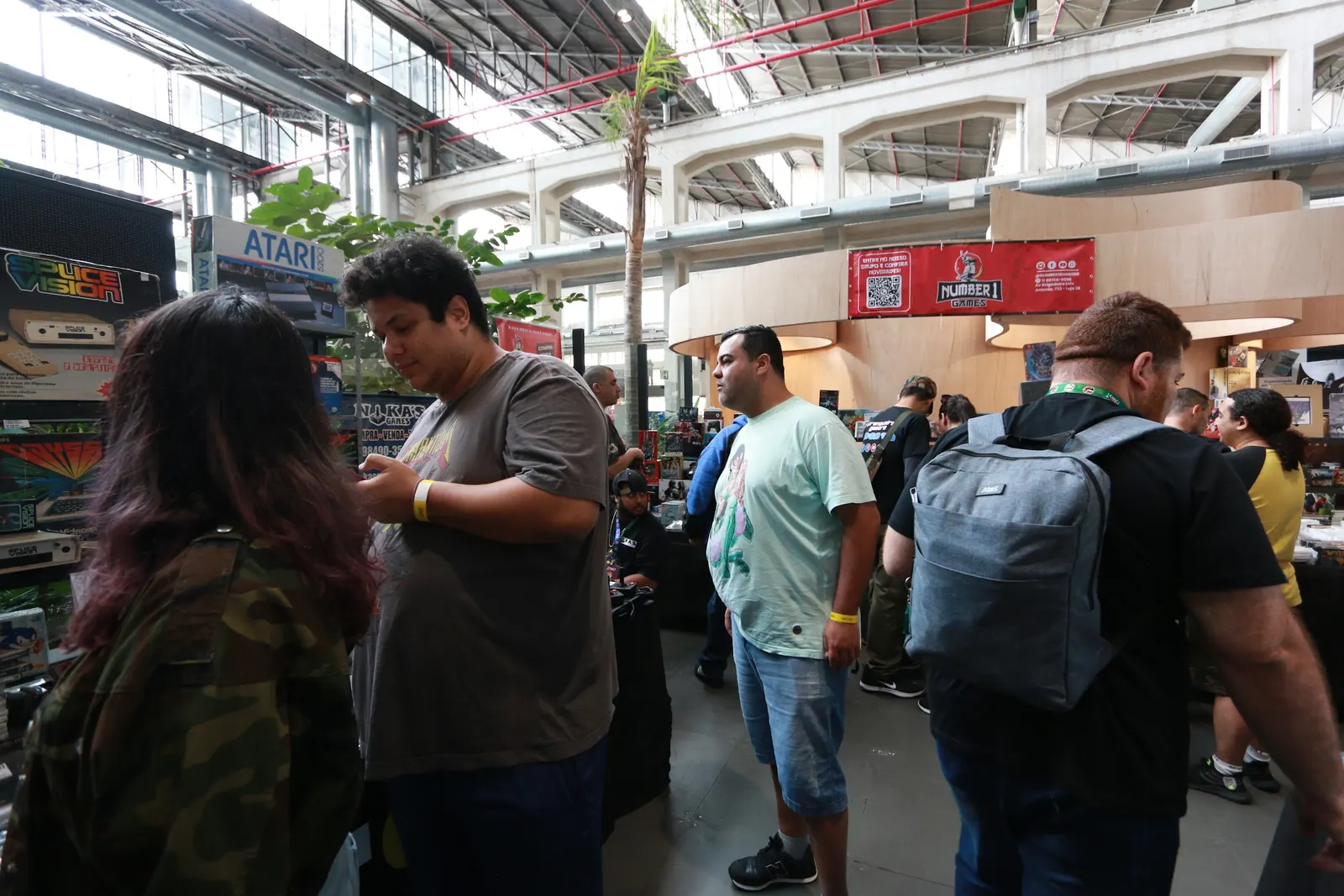 Visitantes garimpando jogos nas mesas dos lojistas