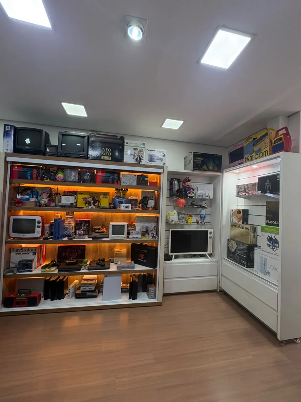 Estante iluminada com consoles e jogos na loja Game Lab, na Liberdade