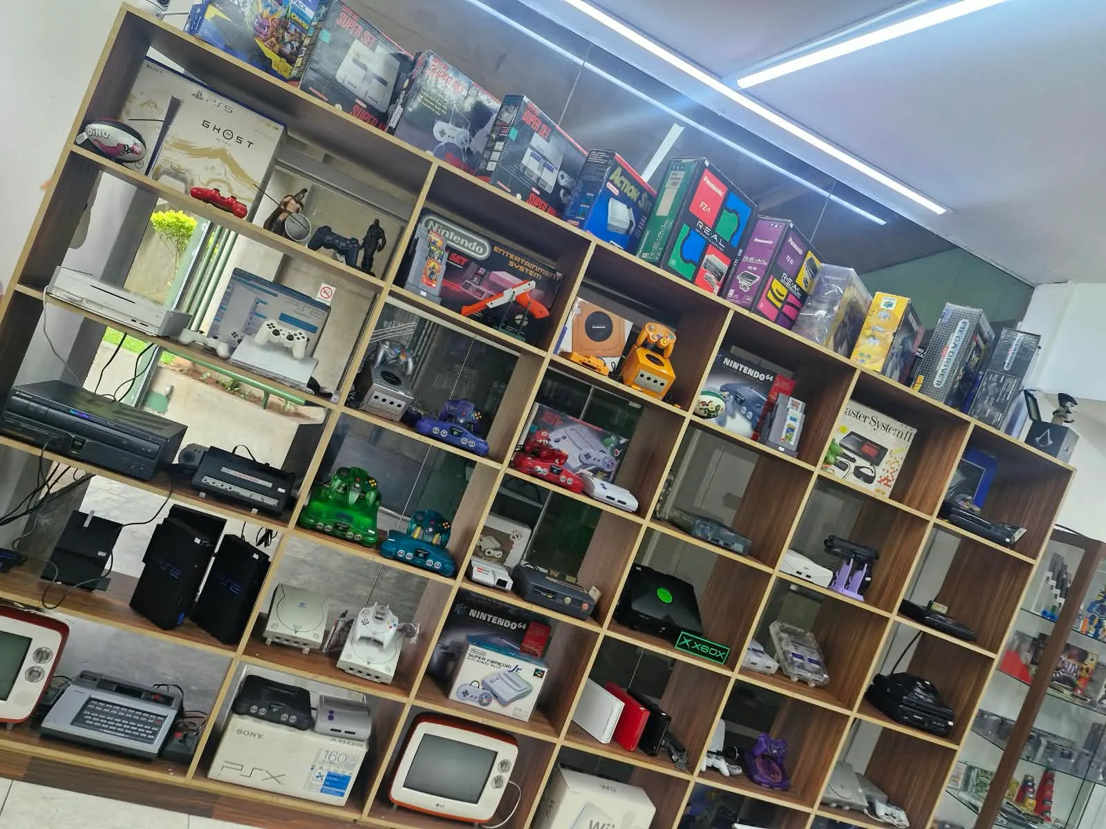 Estante com consoles clássicos na Guiart Games