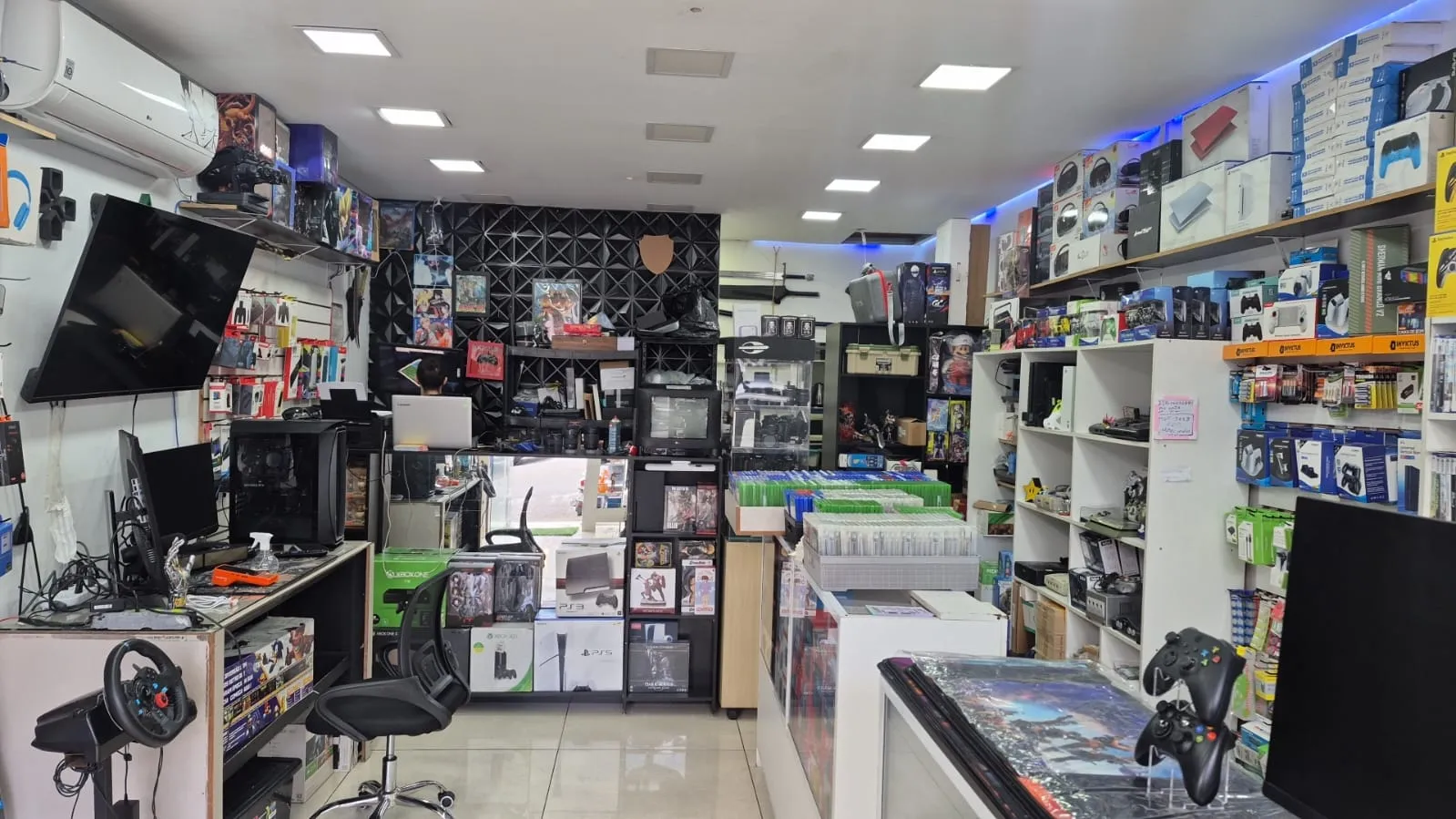Visão do corredor da Natan Games, com bancada de assistência técnica ao fundo