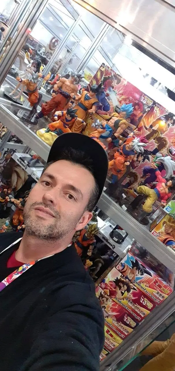Lojista da RetroGeek013 diante de uma vitrine de action figures